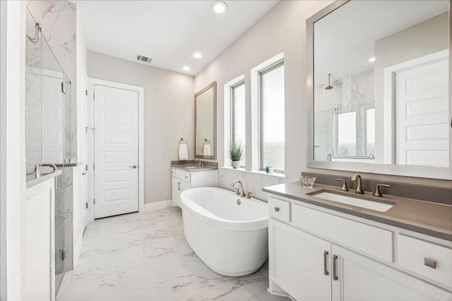 Natural Materials and neutral colors add subtle elegance to the primary bath. Dual vanities provide ample space for two people to comfortably get ready each day. | Image 20
