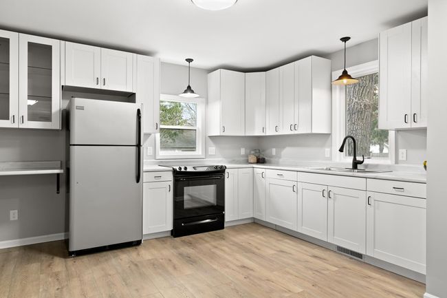 The kitchen is bright and spacious with windows overlooking the backyard. | Image 4