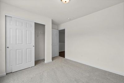 Unfurnished bedroom with light colored carpet and a closet | Image 3