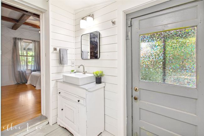 Main Bathroom featuring vanity, tile floors, beamed ceiling, ensuite bath, and exit to back porch. | Image 25