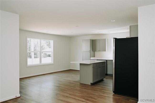 Kitchen featuring stainless steel fridge, hardwood / wood-style flooring, gray cabinets, and a kitchen island | Image 6