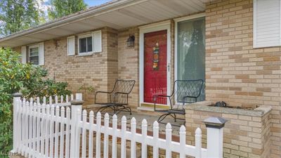 A cherry red door says, "Come in and sit a bit. | Image 3