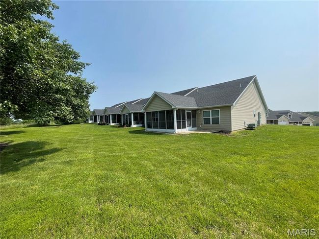 Rear view of house featuring a sunroom and a lawn | Image 21