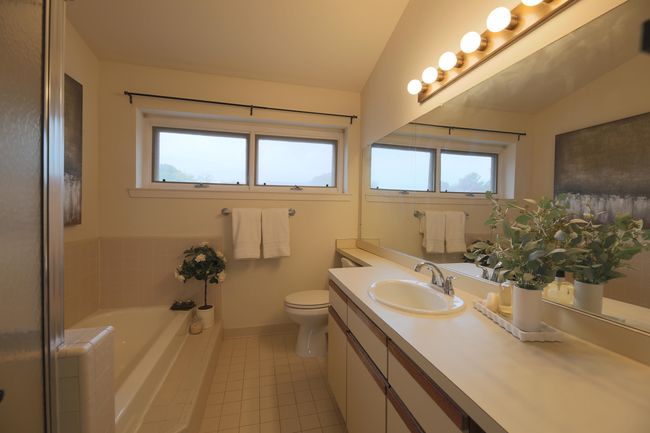Primary ensuite full bath with soaker tub, separate shower and large vanity with storage. | Image 14