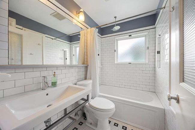 The full bathroom offers so much storage space and multiple shower niches. Not pictured: linen cabinet, drawers and cool tile design in the middle of the floor. | Image 20