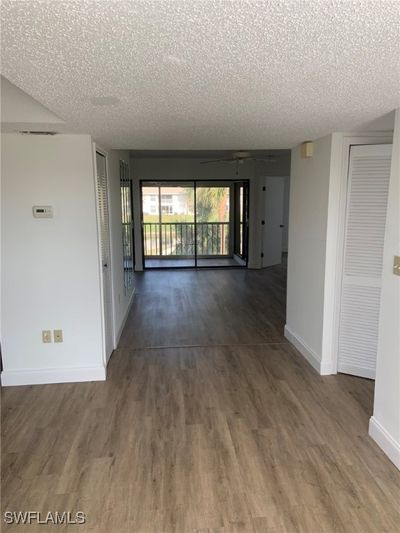 Empty room featuring dark wood-type flooring and a textured ceiling | Image 3