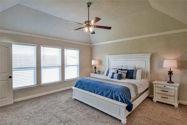 Bedroom featuring light carpet, baseboards, a ceiling fan, and vaulted ceiling | Image 19