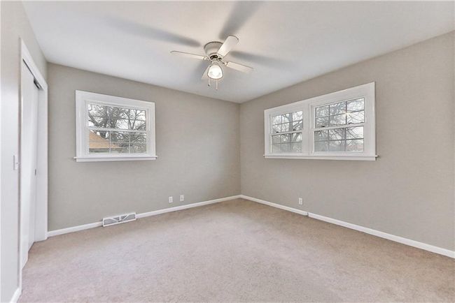 Unfurnished bedroom with ceiling fan, a closet, and light carpet | Image 16