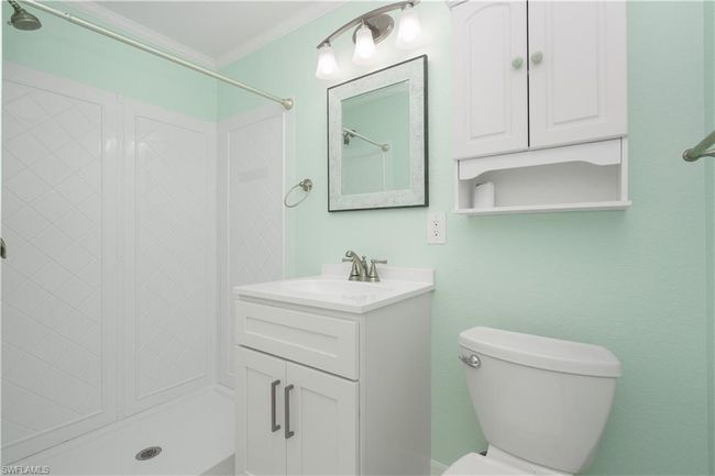 Bathroom featuring ornamental molding, walk in shower, toilet, and vanity. | Image 13