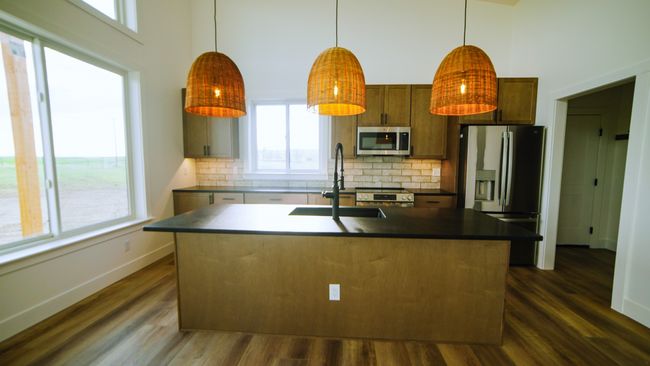 Kitchen with stainless steel appliances, a towering ceiling, decorative backsplash, and dark wood finished floors | Image 26