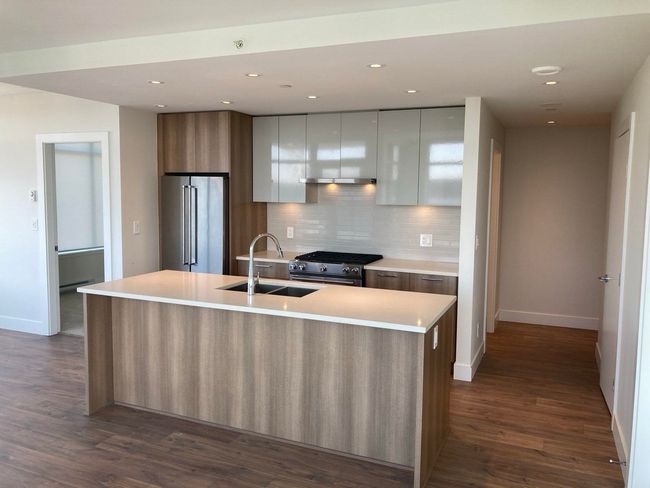 Kitchen featuring high end appliances, baseboards, a sink, and modern cabinets | Image 5