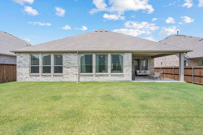 Rear view of property with roof with shingles, a fenced backyard, brick siding, and a patio | Image 32