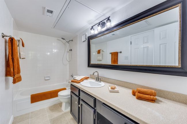Full upstairs bathroom has tile flooring, quartz countertop, spacious vanity and mirror. | Image 13