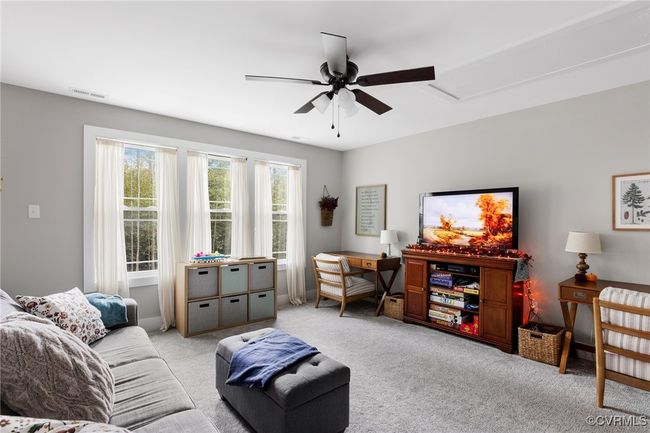 Living room featuring light carpet, a ceiling fan, and visible vents | Image 22