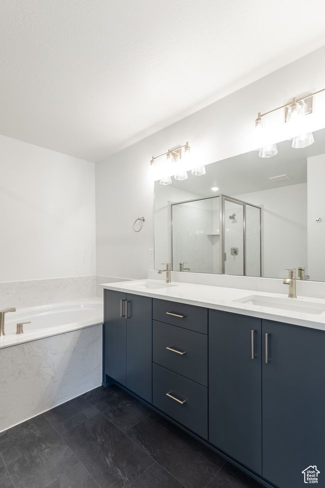 Bathroom featuring a bath, a stall shower, and double vanity | Image 9