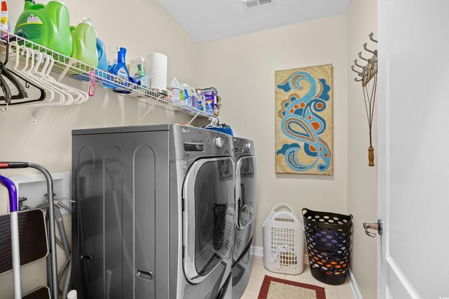 Laundry area with washing machine and clothes dryer and tile patterned floors | Image 30