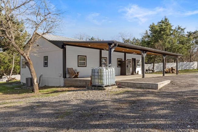 View of front of house featuring metal roof, fence, and central AC unit | Image 5