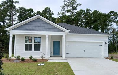 View of front facade featuring a front yard and a garage | Image 1