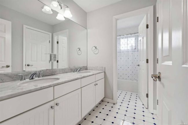 Full bath with double vanity, shower / bath combo with shower curtain, and tile patterned floors | Image 16
