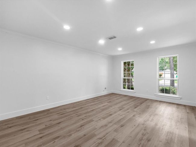 This room features spacious, open living with light wood floors, fresh white walls, and large windows providing ample natural light. Ideal for creating a bright and welcoming space. | Image 19
