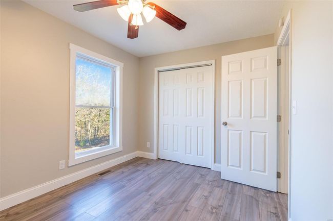 Unfurnished bedroom with light wood-type flooring, a closet, and ceiling fan | Image 16