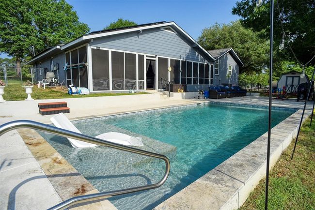 Swimming pool with a sunroom, a shed, and a patio area | Image 28