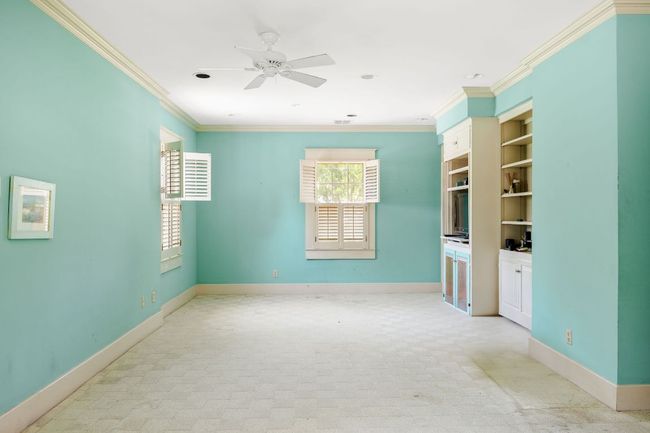 Spare room featuring crown molding, a ceiling fan, and built in features | Image 22