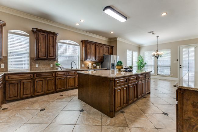 The well appointed kitchen has an oversized island, granite countertops and extensive cabinetry for storage. The walk in pantry is an additional feature you won't want to miss! | Image 9