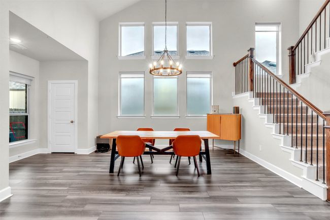 Dining space with stairway, an inviting chandelier, and dark wood-style flooring | Image 4