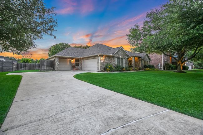 View of front of property with a garage, stone siding, and driveway | Image 7