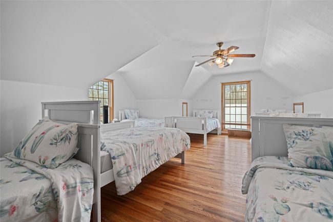 Bedroom with vaulted ceiling, wood finished floors, and ceiling fan | Image 35