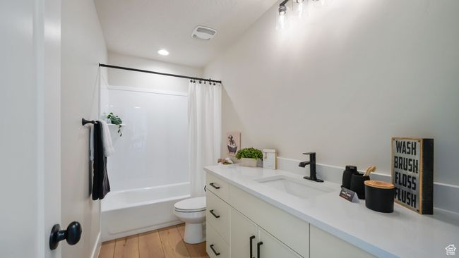 Bathroom featuring vanity, shower / tub combo with curtain, wood finished floors, and recessed lighting | Image 16