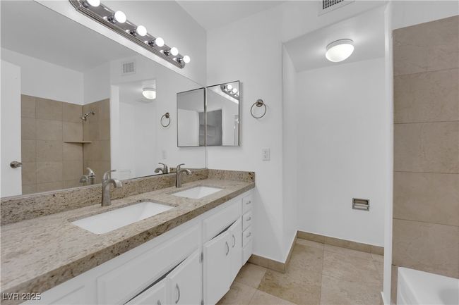 Full bathroom with tiled shower, double vanity, and baseboards | Image 15