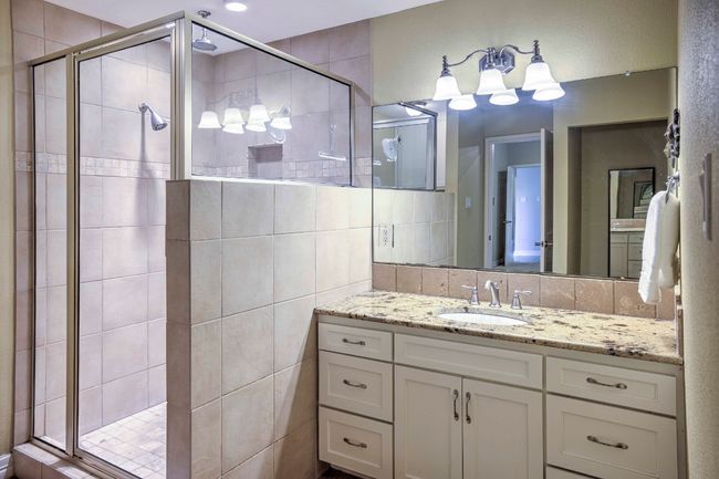 Bathroom with vanity, a stall shower, granite counters, and tile walls | Image 25