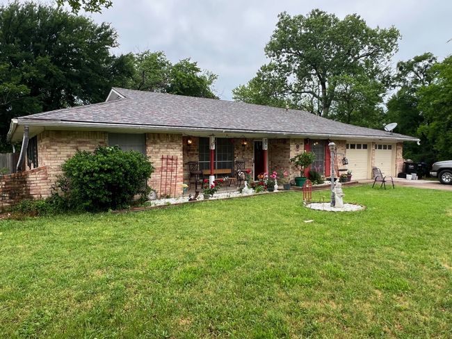 View of front of home featuring a porch, a front yard, brick siding, and a garage | Image 16