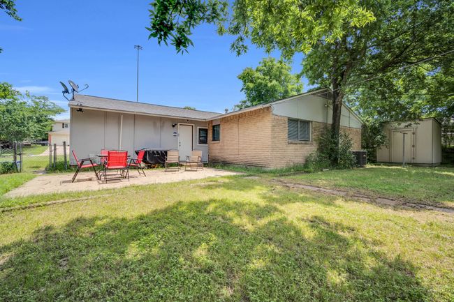 Back of property featuring a patio, a gate, brick siding, a yard, and a storage shed | Image 30