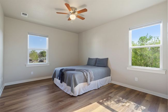 Bedroom with baseboards, wood finished floors, and a ceiling fan | Image 34