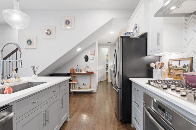 Kitchen featuring stainless steel appliances, light countertops, range hood, and gray cabinets | Image 9