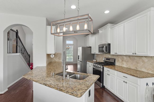 Host your next dinner party with confidence! This masterfully-equipped kitchen features a kitchen island, an abundance of cabinetry and hardware, TONS of counter space, granite countertops and stainless-steel appliances. | Image 6