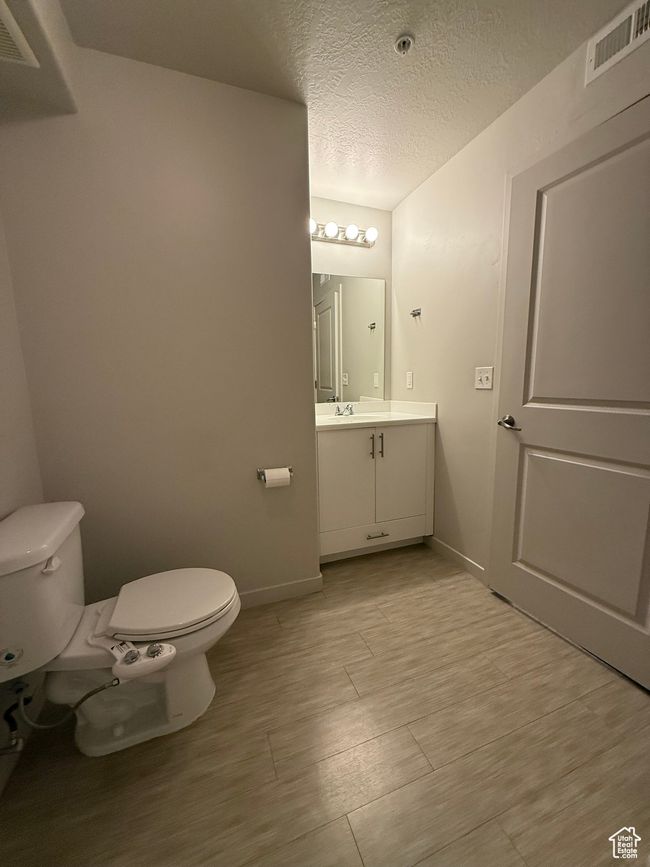 Bathroom featuring vanity, a textured ceiling, and wood finished floors | Image 8