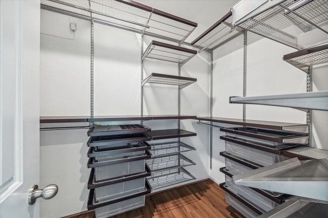 Expansive primary closet with customizable shelving and sleek, modern design. Perfect for organizing your wardrobe effortlessly. | Image 26