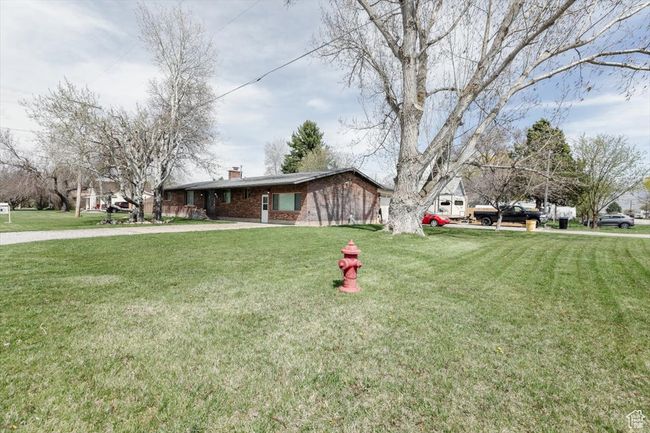 View of front of home featuring brick siding, a front lawn, and a chimney | Image 43