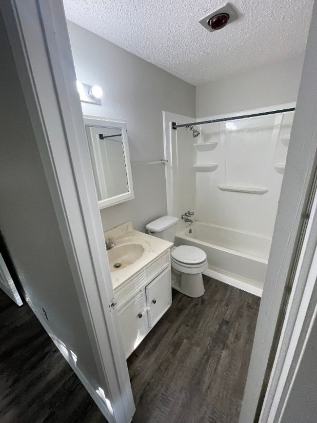 Full bath with wood finished floors, a textured ceiling, vanity, and bathtub / shower combination | Image 9