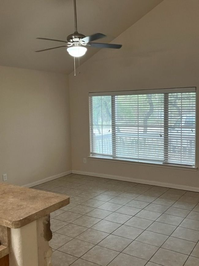 Spare room with ceiling fan, light tile patterned flooring, and vaulted ceilings! | Image 12