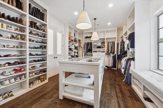 PRIMARY CLOSET. A wonderfully large space which could be a room in itself. Every possible storage need was considered with built in cubbies, racks, drawers, vanity areas and glass display case. | Image 20