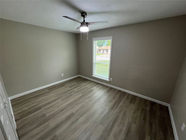 Empty room featuring ceiling fan, wood finished floors, and baseboards | Image 9