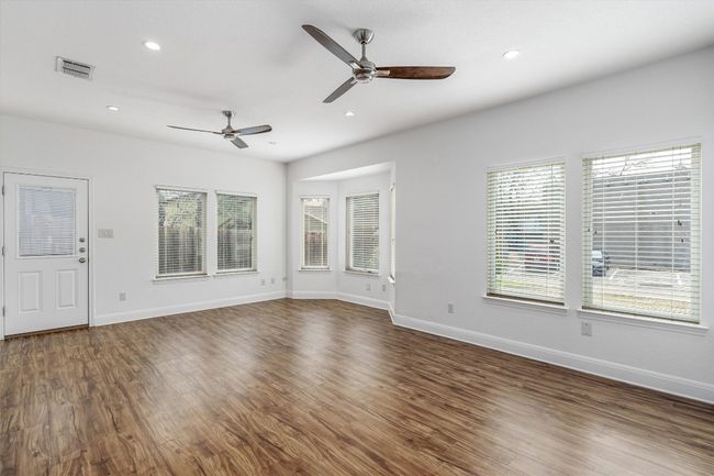 Unfurnished living room with dark wood-type flooring, baseboards, ceiling fan, and a healthy amount of sunlight | Image 6