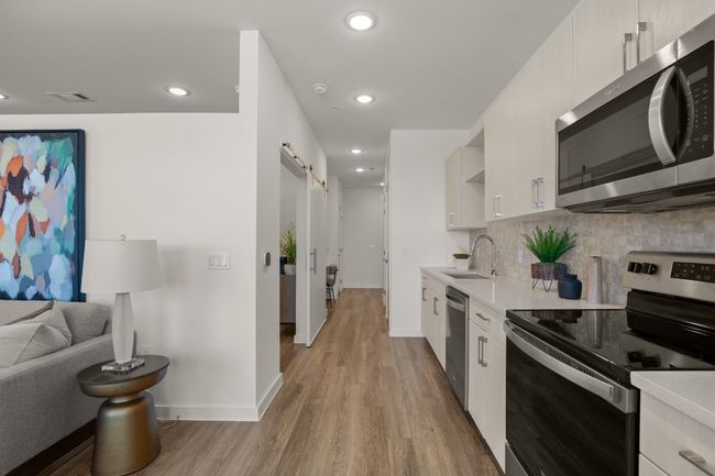 Modern kitchen is open to the living area with an option to add dining table | Image 9