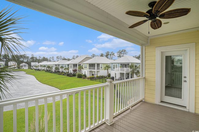 Wooden terrace with a residential view, ceiling fan, and a yard | Image 13