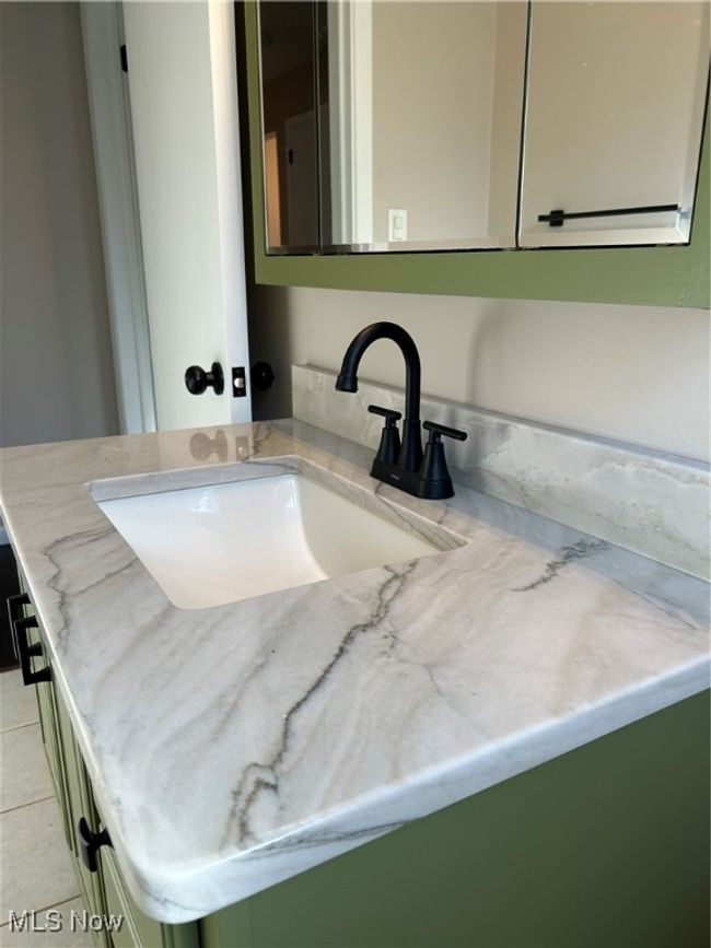 Upscale quartzite counter on vanity. | Image 17